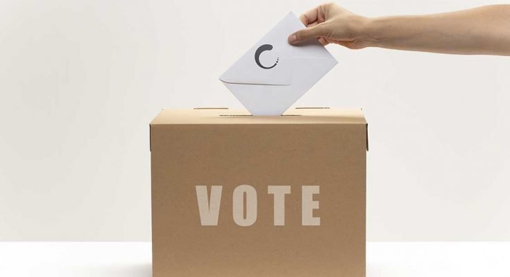 Person putting a vote into a ballot box
