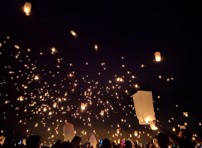 Hundreds of sky lanterns being released against a black sky