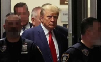 Donald Trump walking out of the Manhattan Court surrounded by police officers